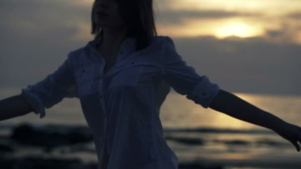 Mulher girando na praia durante o pôr do sol — Vídeo de Stock