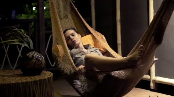 Young woman sleeping on hammock at night — Stock Video