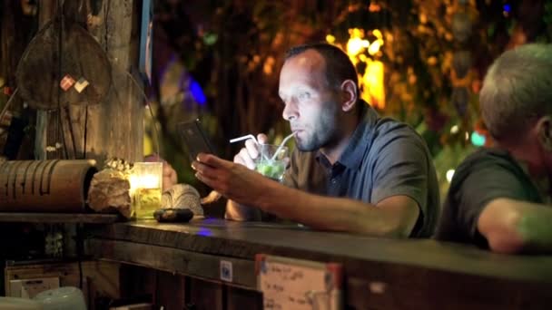 Ο άνθρωπος με το smartphone, πίνοντας ποτό στο café — Αρχείο Βίντεο