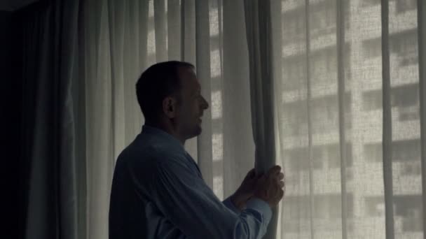 Geschäftsmann enthüllt Vorhänge und bewundert Blick aus Fenster — Stockvideo