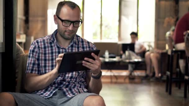 Ο άνθρωπος που χρησιμοποιούν τον υπολογιστή tablet στο καφέ — Αρχείο Βίντεο