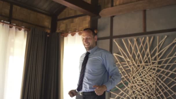 Счастливый бизнесмен прыгает на кровати дома — стоковое видео