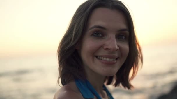 Gelukkige vrouw tijdens zonsondergang op het strand — Stockvideo