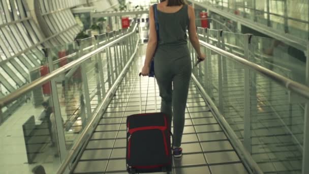 Mujer con maleta caminando en el aeropuerto — Vídeo de stock