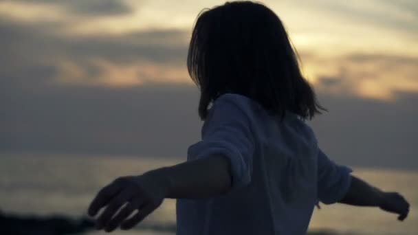 Vrouw draaien ronde op strand tijdens zonsondergang — Stockvideo