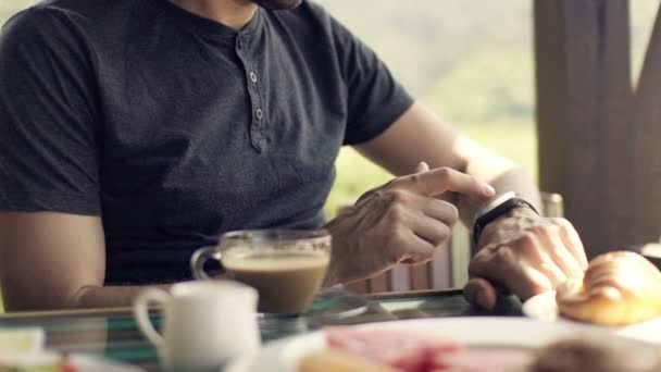 Uomo utilizzando smartwatch durante la colazione — Video Stock