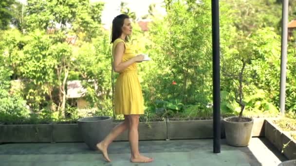 Glückliche Frau trinkt Kaffee auf der Terrasse — Stockvideo