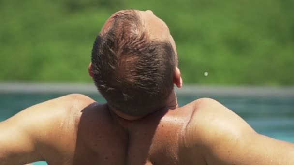 Mann entspannt sich im Schwimmbad — Stockvideo