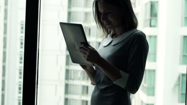 Businesswoman using tablet computer while standing by window — Stock Video