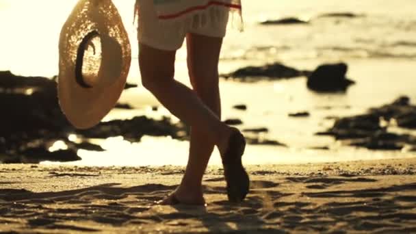 Frau mit Sommerhut geht am Strand spazieren — Stockvideo