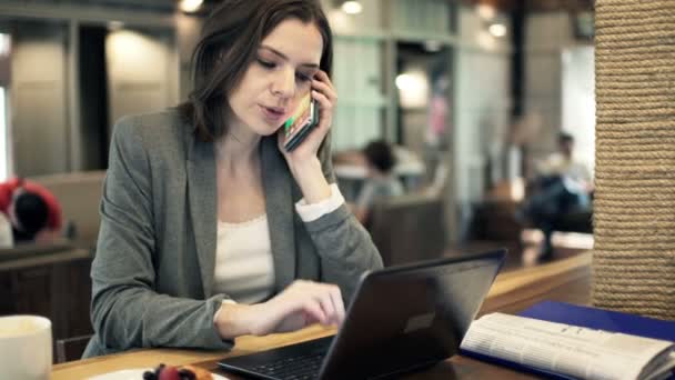 Üzletasszony, mobil és a laptop a kávézóban dolgozik — Stock videók