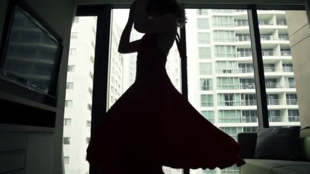 Жінка танцює і обертається біля вікна — стокове відео