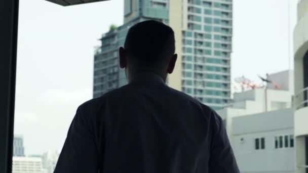 Geschäftsmann geht raus und streckt sich auf Terrasse mit Blick auf die Stadt — Stockvideo