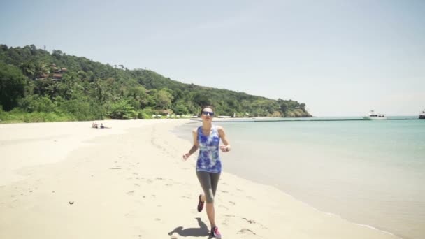 Молодая женщина бегает по тропическому пляжу — стоковое видео