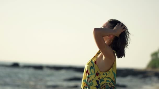 Женщина играет с волосами на пляже — стоковое видео