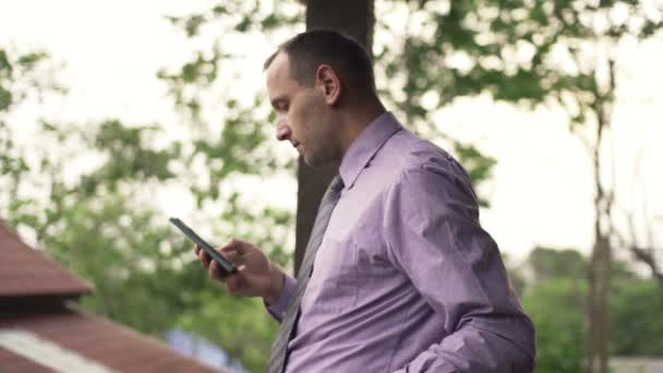 Joven hombre de negocios con smartphone en la terraza — Vídeos de Stock