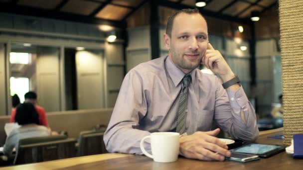 Hombre de negocios hablando de buenas noticias en la cafetería — Vídeos de Stock