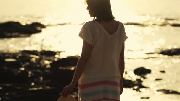 Frau mit Sommermütze steht am Strand — Stockvideo