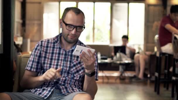 Man kijken naar film op smartphone en broodje eten — Stockvideo