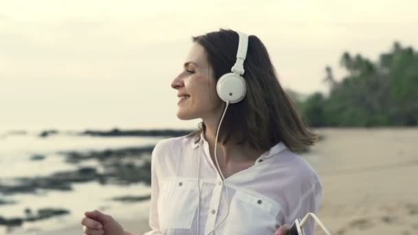 Mujer escuchar música y bailar en la playa — Vídeo de stock