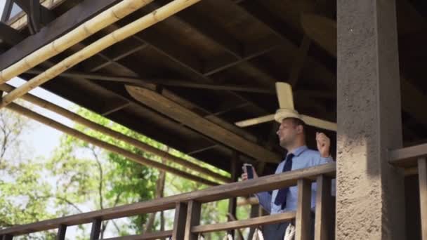 Homme d'affaires écoutant de la musique, dansant et chantant en terrasse — Video