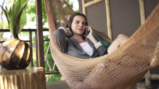 Affärskvinna talar i mobiltelefon i hängmatta — Stockvideo