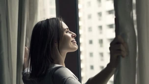 Деловая женщина открывает занавески и любоваться видом из окна — стоковое видео