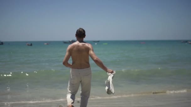 Aufgeregt, junger Mann am Strand — Stockvideo