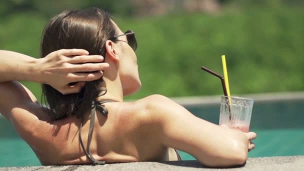 Woman in swimming pool relaxing and drinking cocktail — Stock Video