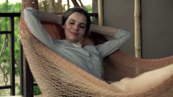 Бізнес-леді розслабляється, лежачи на гамаку — стокове відео