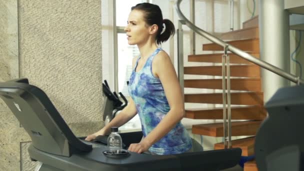 Vrouw draait op loopband machine in sportschool — Stockvideo