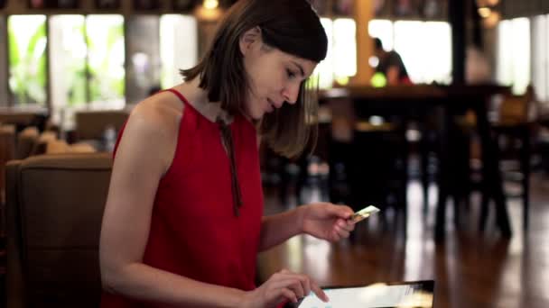 Mujer haciendo compras en línea en el ordenador tableta en la cafetería — Vídeo de stock