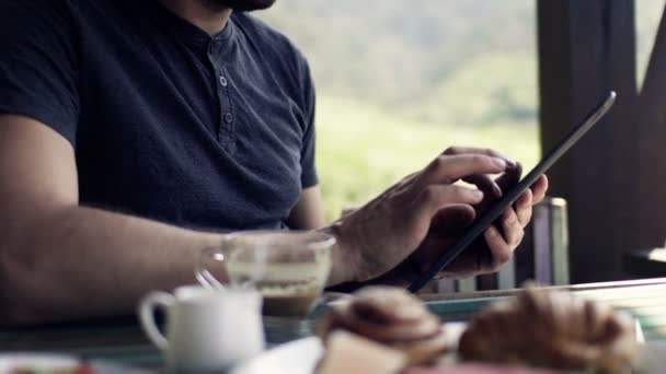 Kahvaltı sırasında tablet bilgisayar kullanan adam — Stok video