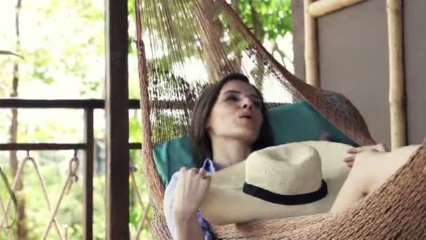 Woman cooling herself with hat on hammock — Stock Video