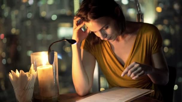 Menu di lettura donna seduta sulla terrazza nel caffè — Video Stock