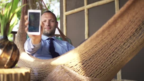 Biznesmen biorąc selfie zdjęcie z smartphone na hamaku — Wideo stockowe