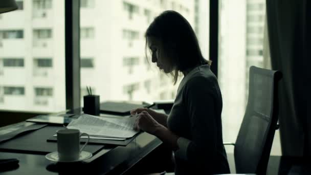 Businesswoman writing notes in documents in office — Stock Video