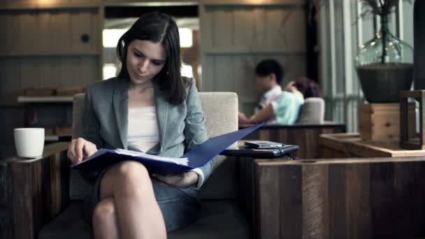 Femme d'affaires travaillant avec des documents assis dans un café — Video