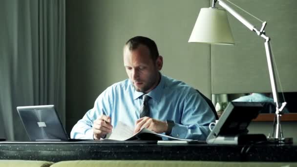 Businessman writing notes in documents in office — Stock Video