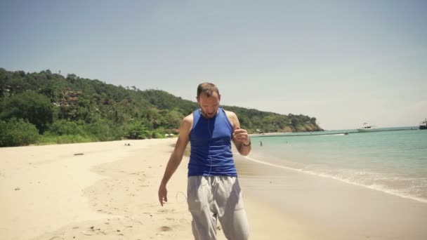 Jogger controleren van tijd en puls aan smartwatch op strand — Stockvideo