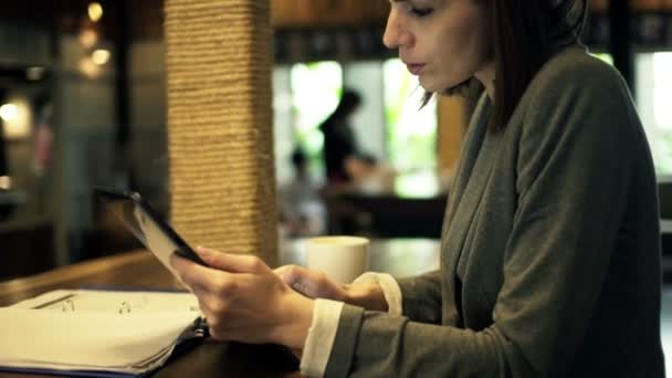 Kobieta pracuje jeden komputer tablet w kawiarni — Wideo stockowe