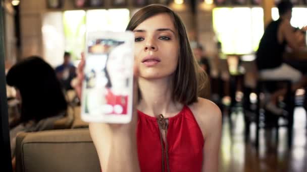 Жінка бере селфі фотографію з мобільним телефоном в кафе — стокове відео