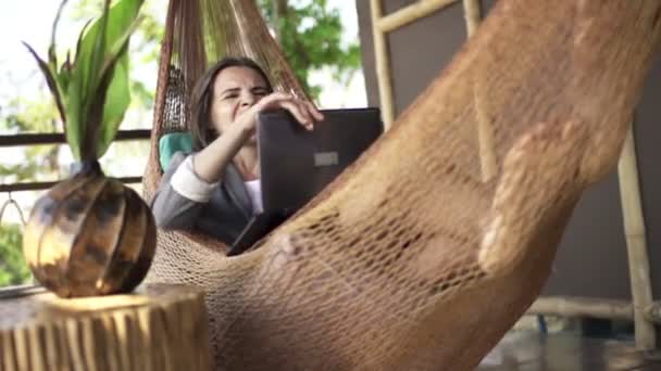 Mujer de negocios con el ordenador portátil acostado en la hamaca — Vídeo de stock