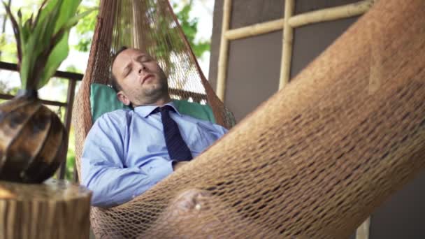 Hombre de negocios durmiendo en la hamaca en la terraza — Vídeos de Stock