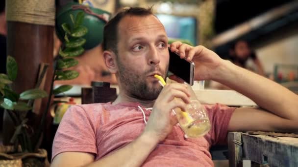 Man praten op mobiel en cocktail drinken — Stockvideo