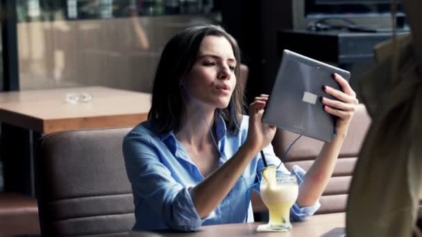 Woman watching movie on tablet computer in cafe — Stock Video