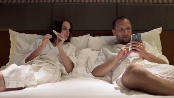 Couple parler et utiliser smartphone sur le lit — Video