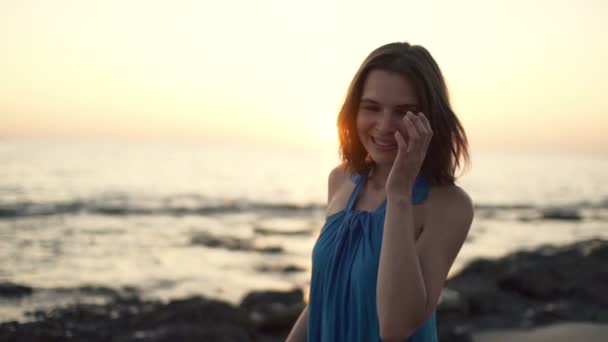 Mujer feliz durante la puesta del sol en la playa — Vídeos de Stock