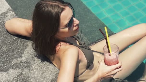 Woman relaxing and drinking cocktail by pool — Stock Video