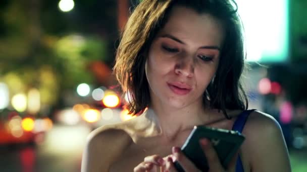 Femme avec smartphone debout en ville la nuit — Video